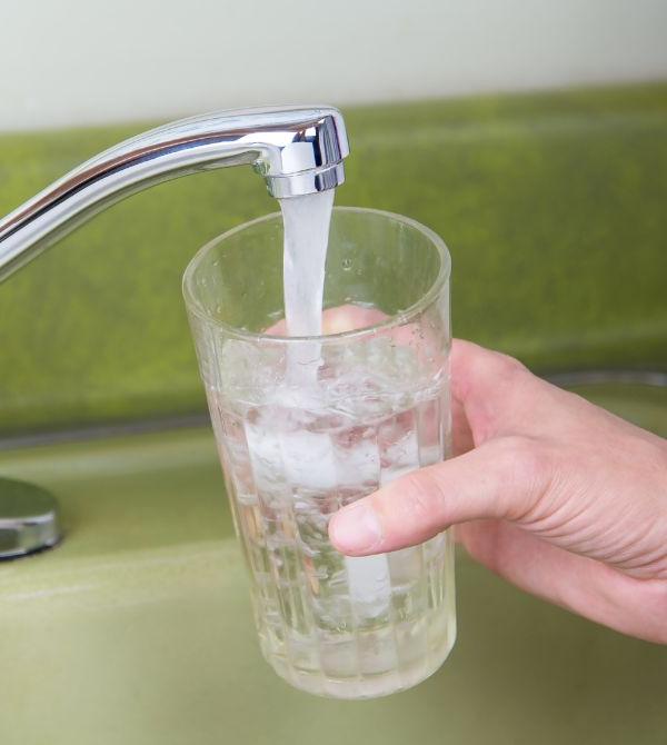 Person getting a glass of tap water